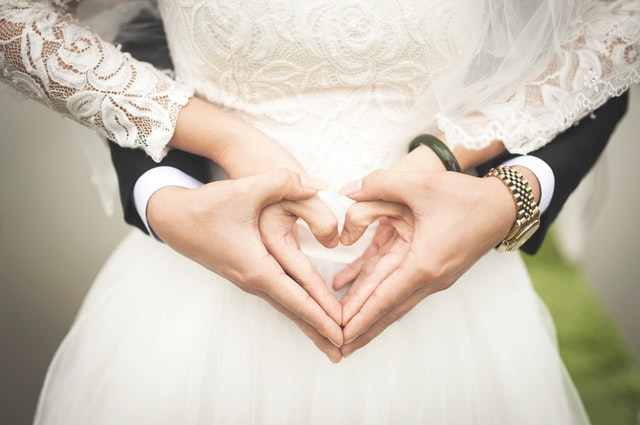 Ruce ženicha a nevěsty spojené v srdce